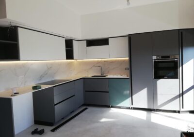 Cucina moderna ristrutturata a Milano con mobili eleganti, piastrelle resistenti e piano di lavoro funzionale, ideale per appartamenti e case