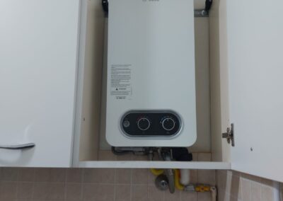Tecnico che installa e manutiene due caldaie a condensazione Vaillant, Baxi, Ariston, Beretta o Ferroli, impianto moderno di riscaldamento domestico